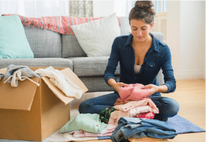 femme qui trie des affaires assise sur le sol